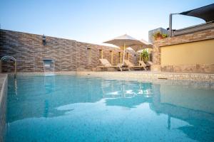 a swimming pool with some chairs and an umbrella at Hotel & Ryad Art Place Marrakech in Marrakesh