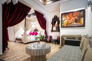 a living room with a bed and a table at Hotel & Ryad Art Place Marrakech in Marrakesh