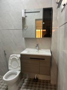 a bathroom with a toilet and a sink and a mirror at Appartement confort keur massar in Rufisque