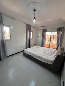 a bedroom with a bed and two windows at Appartement confort keur massar in Rufisque +26 photos