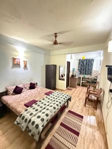 a bedroom with a large bed and a living room at spectrum hub beach side apartment in Candolim