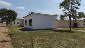 a group of buildings in a field with trees at Muzhi Wetu Lodge in Chanamo +1 photo