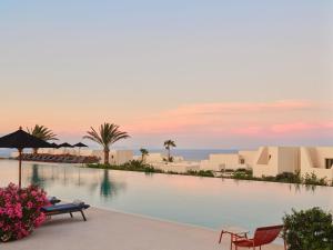 a view of the infinity pool at the resort at Noūs Santorini, a Member of Design Hotels in Mesaria