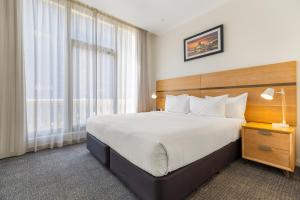 a bedroom with a large bed and a large window at Mantra Adelaide Central in Adelaide +46 photos