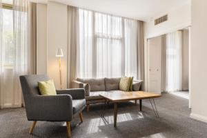 a living room with a couch and two chairs and a coffee table at Mantra Adelaide Central in Adelaide
