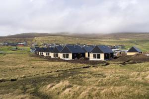 a row of houses on a hill in a field at The Lakehouse in Miðvágur