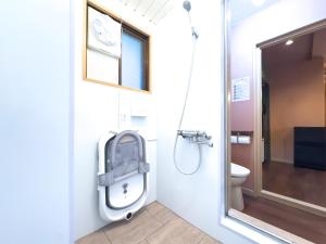 a bathroom with a toilet and a shower at Meijo Mikan Stay in Nagoya
