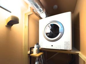 a washing machine on a shelf in a room at Meijo Mikan Stay in Nagoya +14 photos