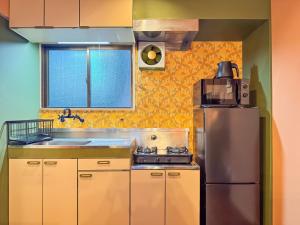 a kitchen with a stainless steel refrigerator and a sink at Meijo Mikan Stay in Nagoya