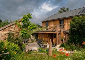 a wooden house with a garden in front of it at Chez Walter et Camille in Saint-Cernin-de-Larche