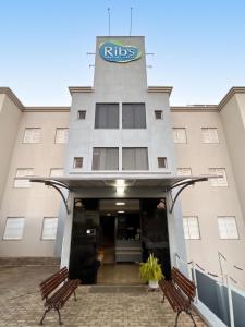 a hotel with two benches in front of a building at Ribs Hotel in Piauí