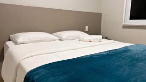 a large white bed with a towel on top of it at Ribs Hotel in Piauí