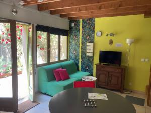 a living room with a green couch and a table at La Maisonnette in Les Andelys