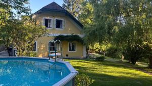 a house with a swimming pool in front of a yard at Wienerwaldhof in Irenental