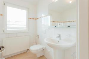 a white bathroom with a toilet and a sink at Chalet SOLYMONT by MoniCare in Seefeld in Tirol +28 photos