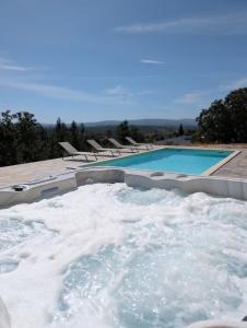 a jacuzzi tub with snow next to a swimming pool at Casa na Colina - Private Pool & Jacuzzi in Santiago da Guarda +5 photos