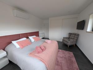 a bedroom with a bed with pink towels on it at Casa na Colina - Private Pool & Jacuzzi in Santiago da Guarda