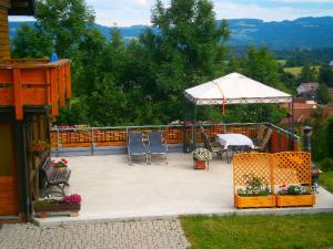 eine Terrasse mit einem Tisch, Stühlen und einem weißen Regenschirm in der Unterkunft Ferien auf dem Steingrubenhof in Sankt Peter