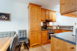 a kitchen with wooden cabinets and a table and chairs at Haus MARGOT by MoniCare in Seefeld in Tirol