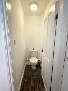 a small bathroom with a toilet and a door at Premium Bedroom Escape in Hull