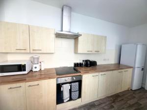 a kitchen with wooden cabinets and a white refrigerator at Premium Bedroom Escape in Hull