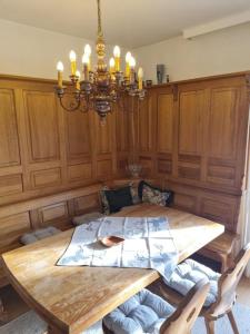 a dining room with a wooden table and a chandelier at Appartement THERESE by MoniCare in Seefeld in Tirol