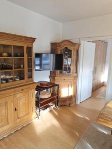 a living room with a tv and a wooden hutch at Appartement THERESE by MoniCare in Seefeld in Tirol