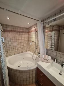 a bathroom with a large tub and a sink at Appartement THERESE by MoniCare in Seefeld in Tirol