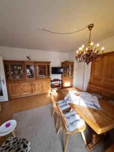 a living room with a wooden table and a chandelier at Appartement THERESE by MoniCare in Seefeld in Tirol +9 photos