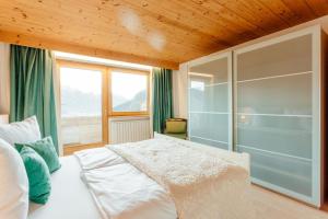 a bedroom with a large white bed and a window at Appartement RUDI by MoniCare in Reith bei Seefeld
