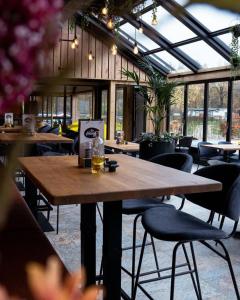 a large wooden table in a restaurant with chairs at Vakantiepark de Witte Berg in Ootmarsum +38 photos