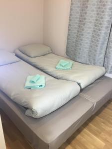 two beds in a room with towels on them at Suur-Ameerika Apartment in Tallinn