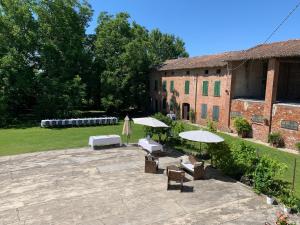 a patio with umbrellas and chairs and a building at Corte Croce in Gonzaga
