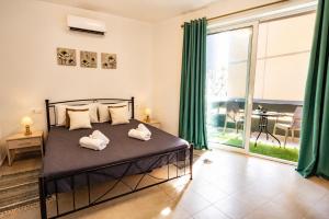 a bedroom with a bed and a large window at Maquestas Modern Apartments in Archangelos