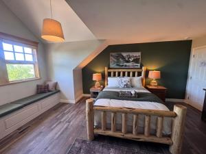 a bedroom with a large bed and a green wall at The Wandering Antler - Bragg Creek in Bragg Creek +18 photos
