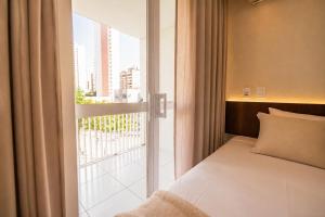 a bedroom with a bed and a window with a balcony at Hotel Rotorua inn Fortaleza - Beira Mar in Fortaleza +78 photos