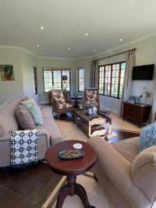 a living room with couches and a table at Acacia House in Winterton