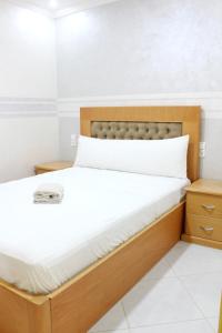 a bed with a wooden headboard in a room at Apart al hoceima in Al Hoceïma