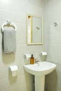 a white bathroom with a sink and a mirror at Apart al hoceima in Al Hoceïma