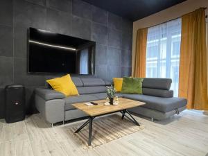a living room with a couch and a table at Ancram SPA Miskolc in Miskolc