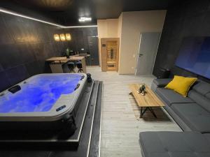a large bath tub in a living room with a couch at Ancram SPA Miskolc in Miskolc