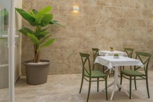 a dining room with a table and chairs and a plant at Casa Lina Suites in Sliema