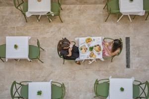 an overhead view of two people sitting at tables eating food at Casa Lina Suites in Sliema