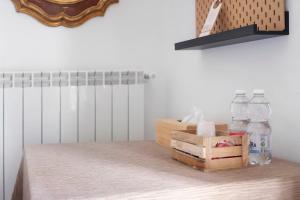 a shelf with bottles and a box on a table at Il Leone Bianco Affittacamere in Albenga +107 photos