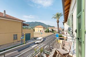 a balcony with two chairs and a palm tree at Il Leone Bianco Affittacamere in Albenga