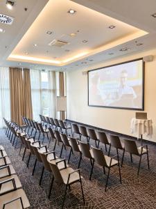 a lecture room with a screen and chairs at Park Inn by Radisson Linz in Linz