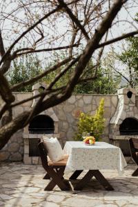 a table and chairs with a table and a stone oven at Step to Kotor bay St-oliv in Kotor +22 photos