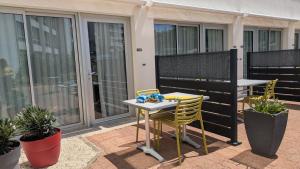 a table and chairs on a patio with a balcony at Résidence avec Piscine face au port 200m plage in La Rochelle