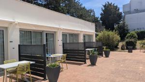 a patio with tables and chairs in front of a building at Résidence avec Piscine face au port 200m plage in La Rochelle