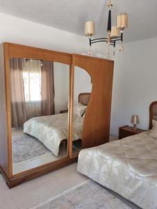 a bedroom with a mirror with a bed in it at home byrsa in Douar ech Chott